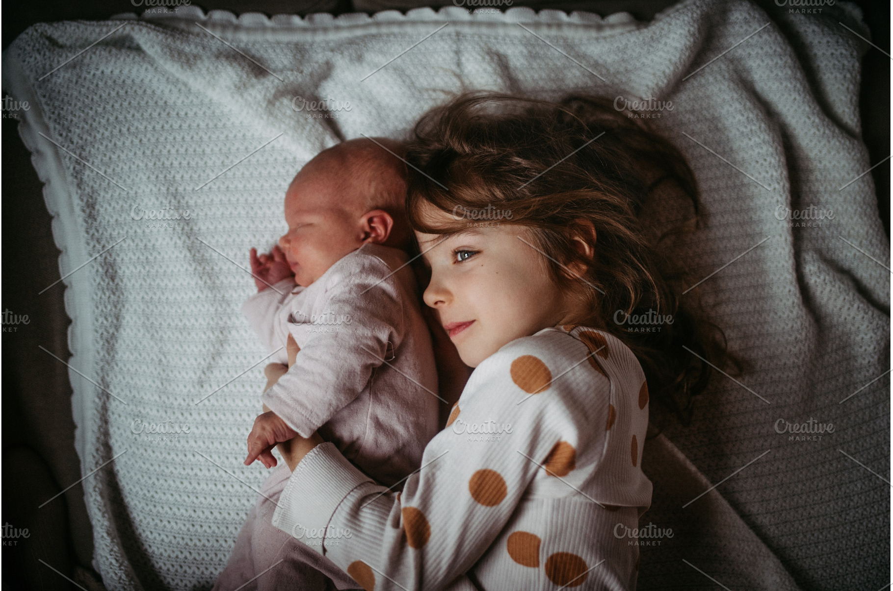 Young girl holding newborn sister, a Person Photo by HalfPoint