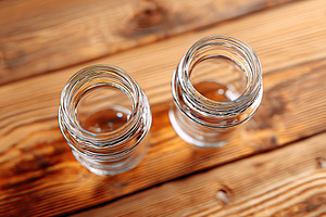 Empty glass bottles positioned on a wooden table with a simple, rustic aestheti, a Photo by AlyaAnd