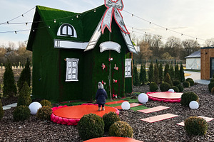 Festive outdoor display featuring a decorated green house with vibrant holiday, a Photo by AS photostudio