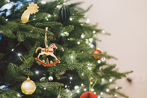 Stylish christmas horse toy hanging on xmas tree branch with fes, a Holiday Photo by Sonjachni