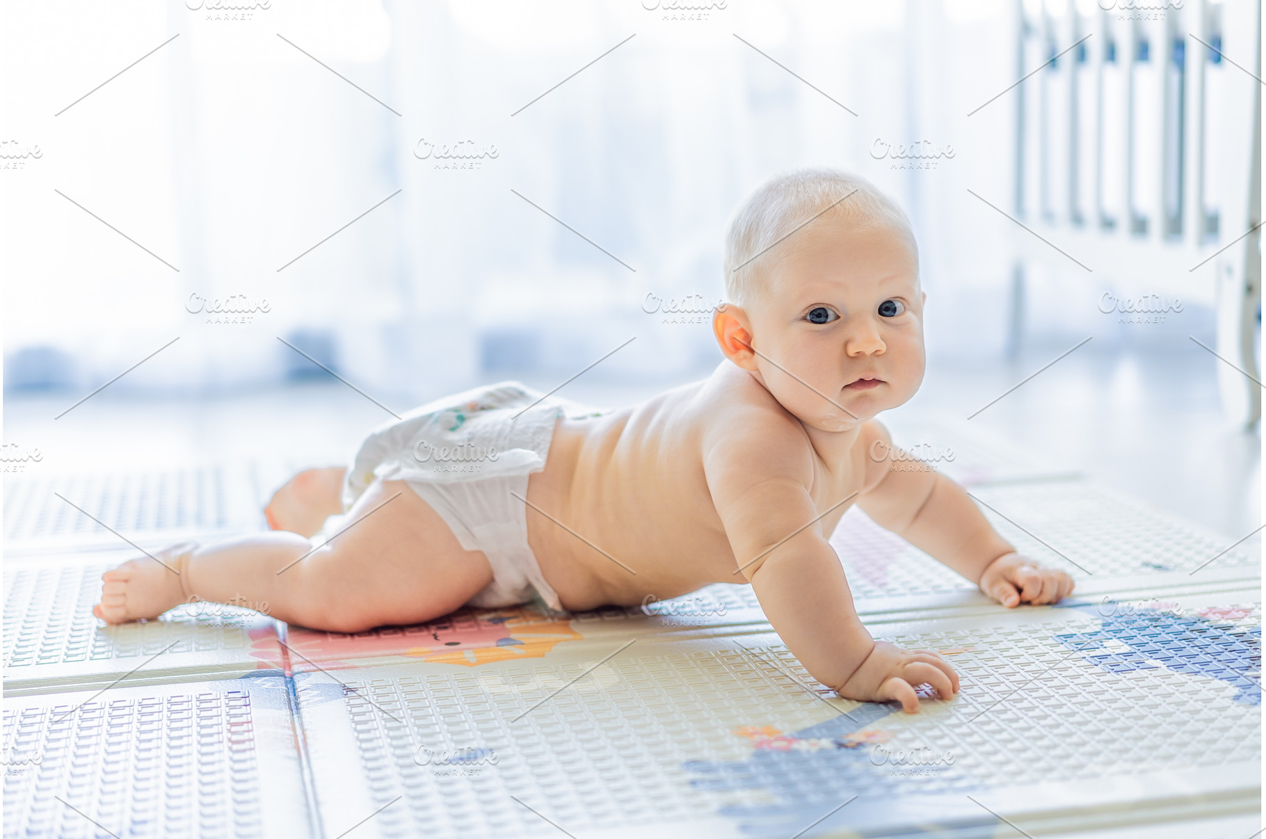 Baby lying on play mat learning to, a Background Photo by Elizaveta Galitskaya