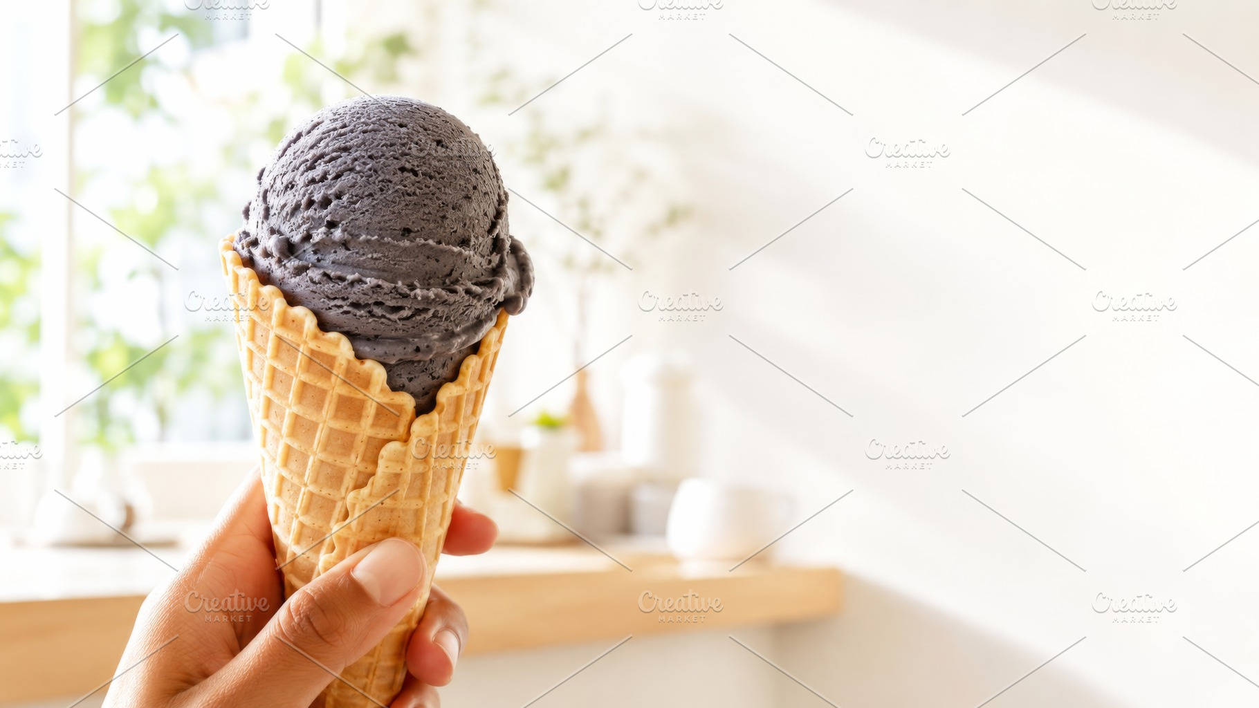 Black sesame ice cream cone in a han, a Photo by Dvoevnore photos