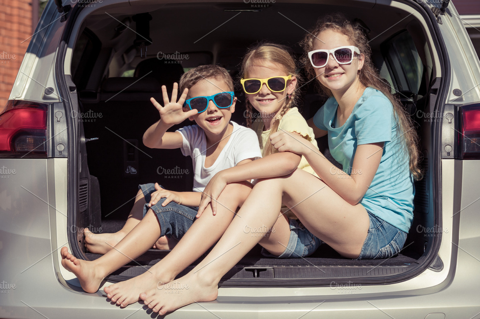 Happy kids sitting in the car featuring car, child, and family, a Person Photo by altanaka
