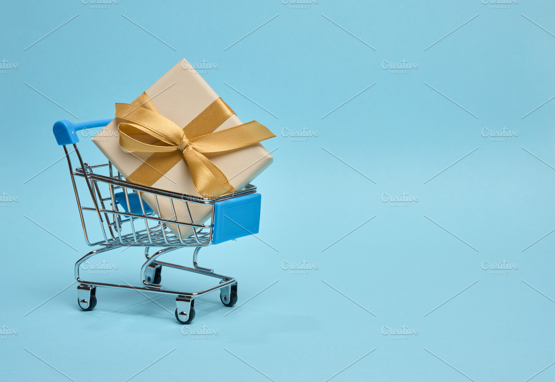 Miniature shopping cart with gift box, beige packaging, blue ba, a Holiday Photo by ndanko