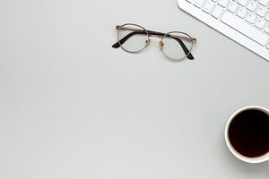 Minimal morning workspace with coffee cup, keyboard, and glasses fostering focu, a Photo by matucha