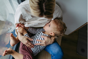 Mother breastfeeding her toddler son, a Person Photo by HalfPoint