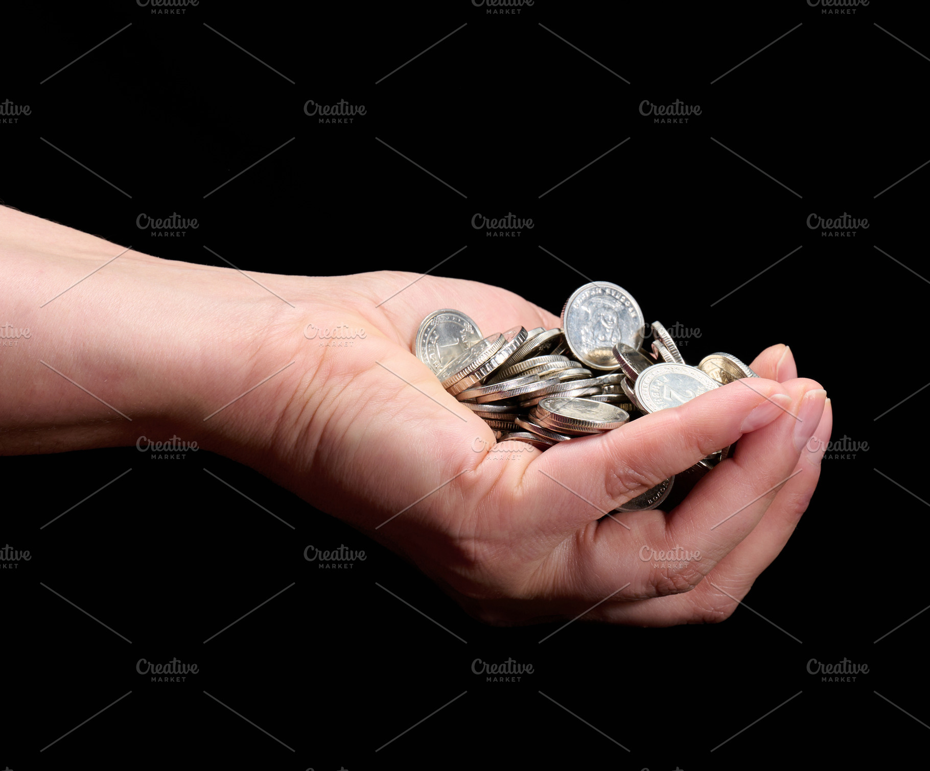 Hand holding a pile of silver coins on a black background, a Business Photo by ndanko