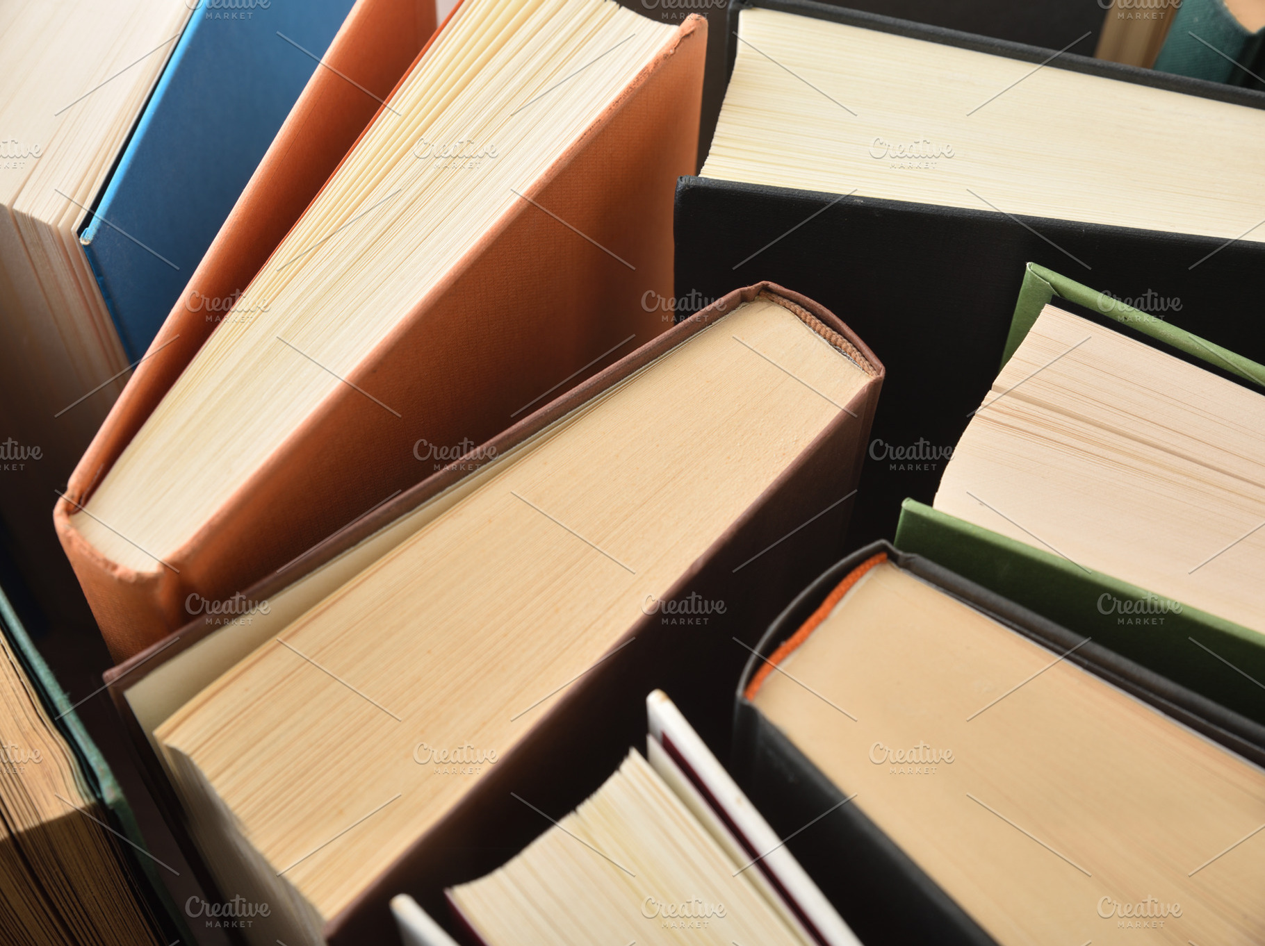 Detail of the top edge of books with multi-colored covers, a School & Education Photo by Davizro's Market