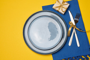 Festive table setting on a yellow background with a gray plate a, a Food & Drink Photo by ndanko