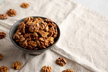 Raw Walnut Halfs in a Bowl, side view. Copy space.