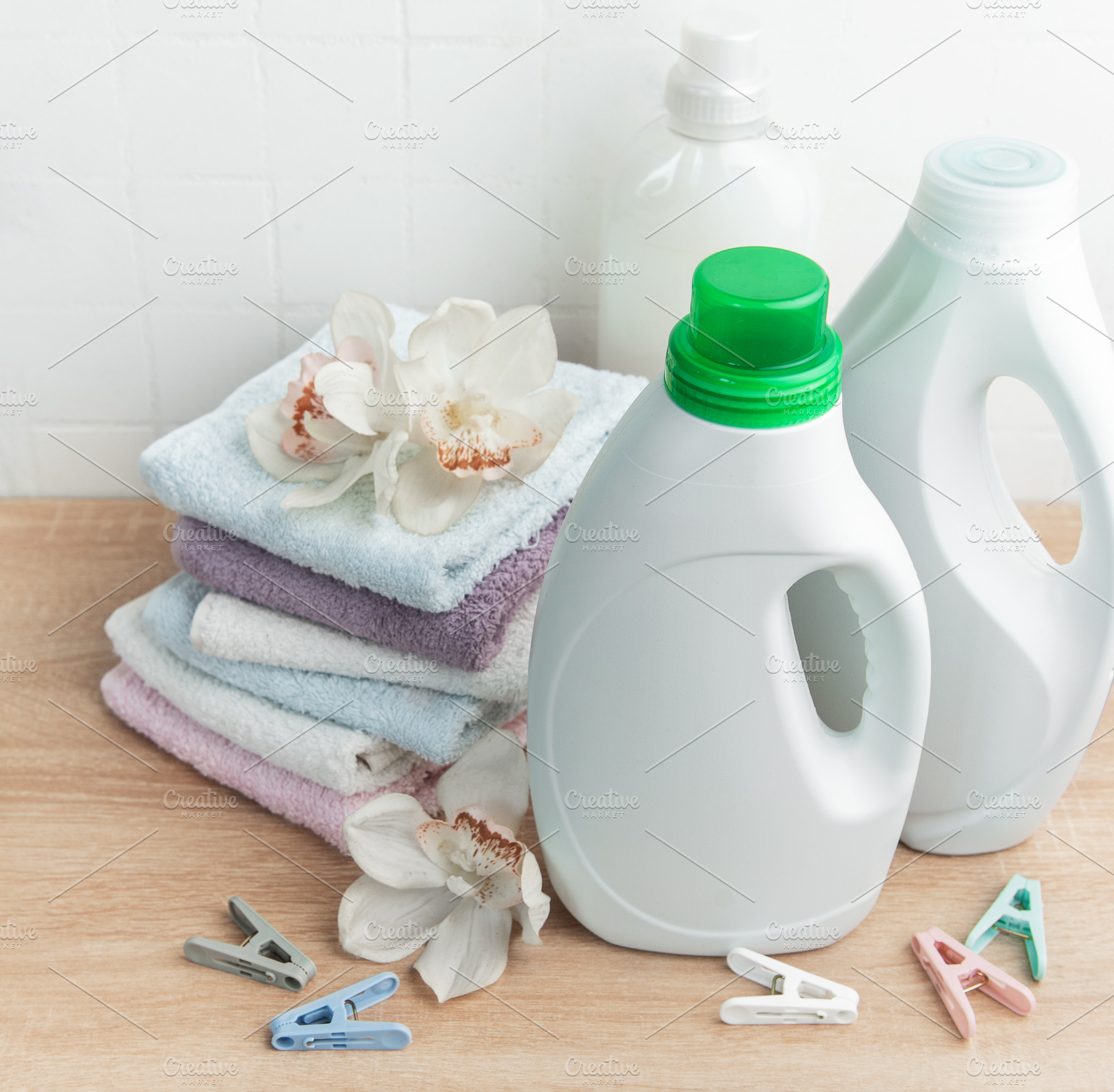 Laundry detergent and fabric softener bottles with fresh towels, an Industrial Photo by Olena Rudo