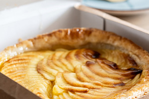 Fresh apple puff pastry tart in cardboard bakery box, a Photo by etorres69