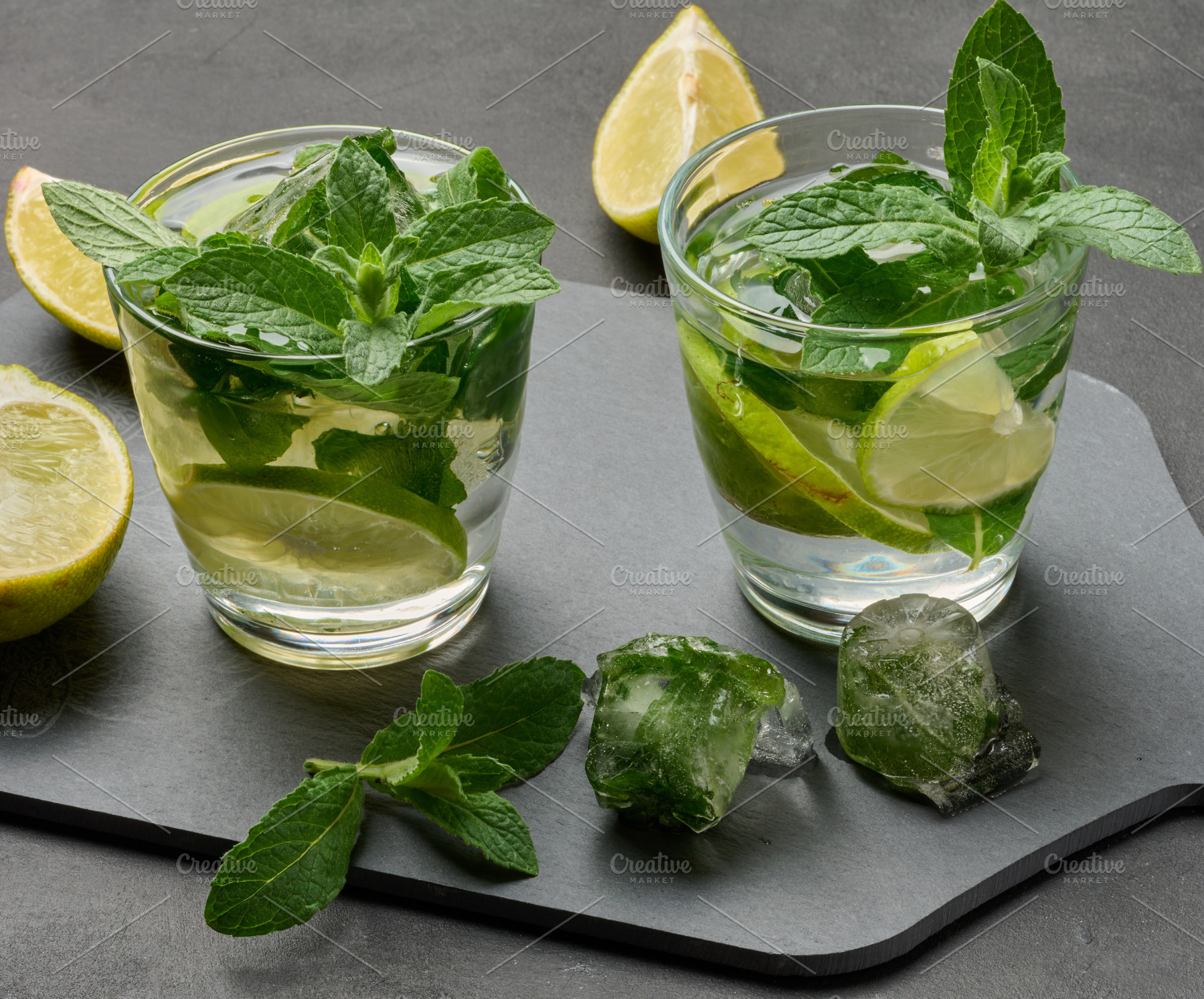 Refreshing mojito cocktail with lime, mint, and ice on dark back, a Food & Drink Photo by ndanko