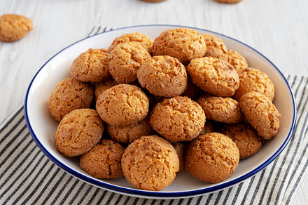 Homemade Sweet and Crunchy Amaretti on a Plate, side view. Close, a Food & Drink Photo by LiudmylaChuhunova