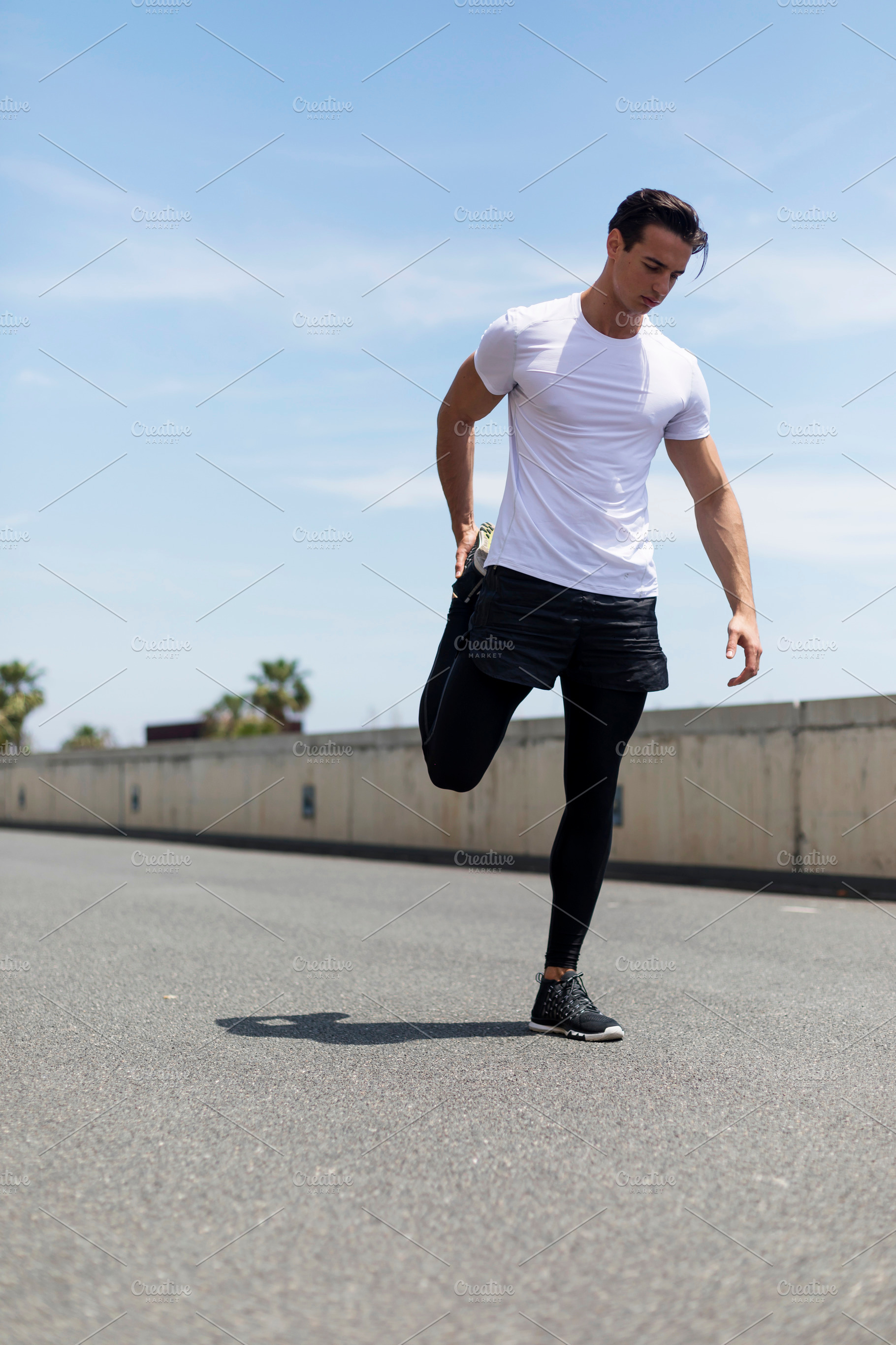 Title: Athletic man stretching outdoors before running, a Person Photo by RF Images