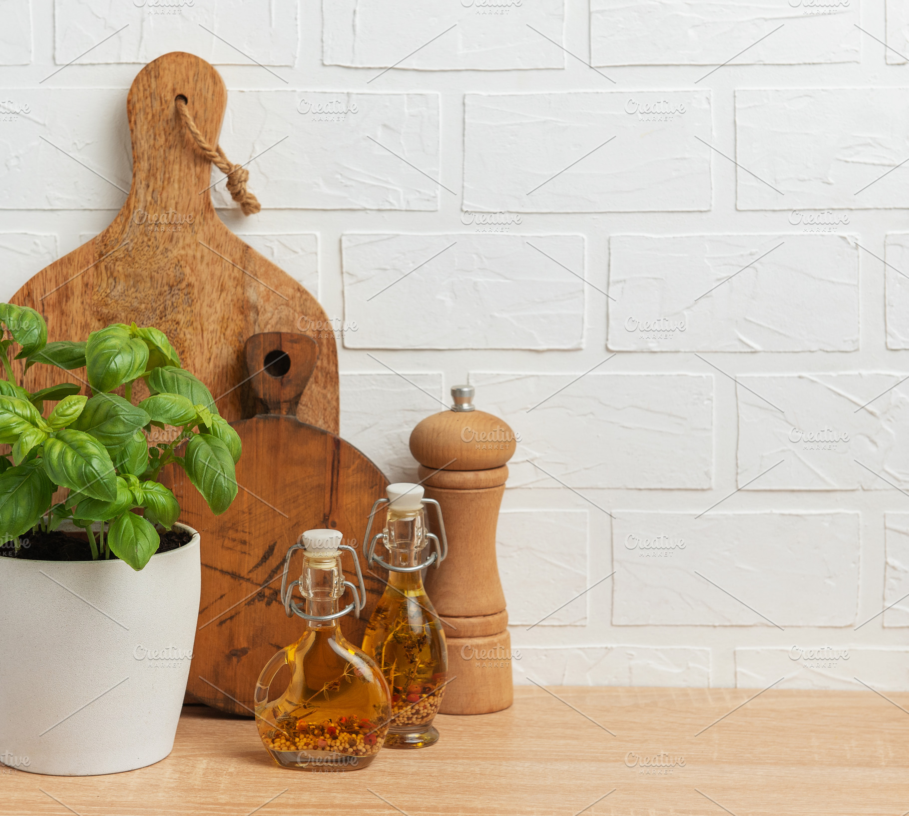 Fresh basil, olive oil, pepper mill and cutting boards resting o, a Food & Drink Photo by Olena Rudo