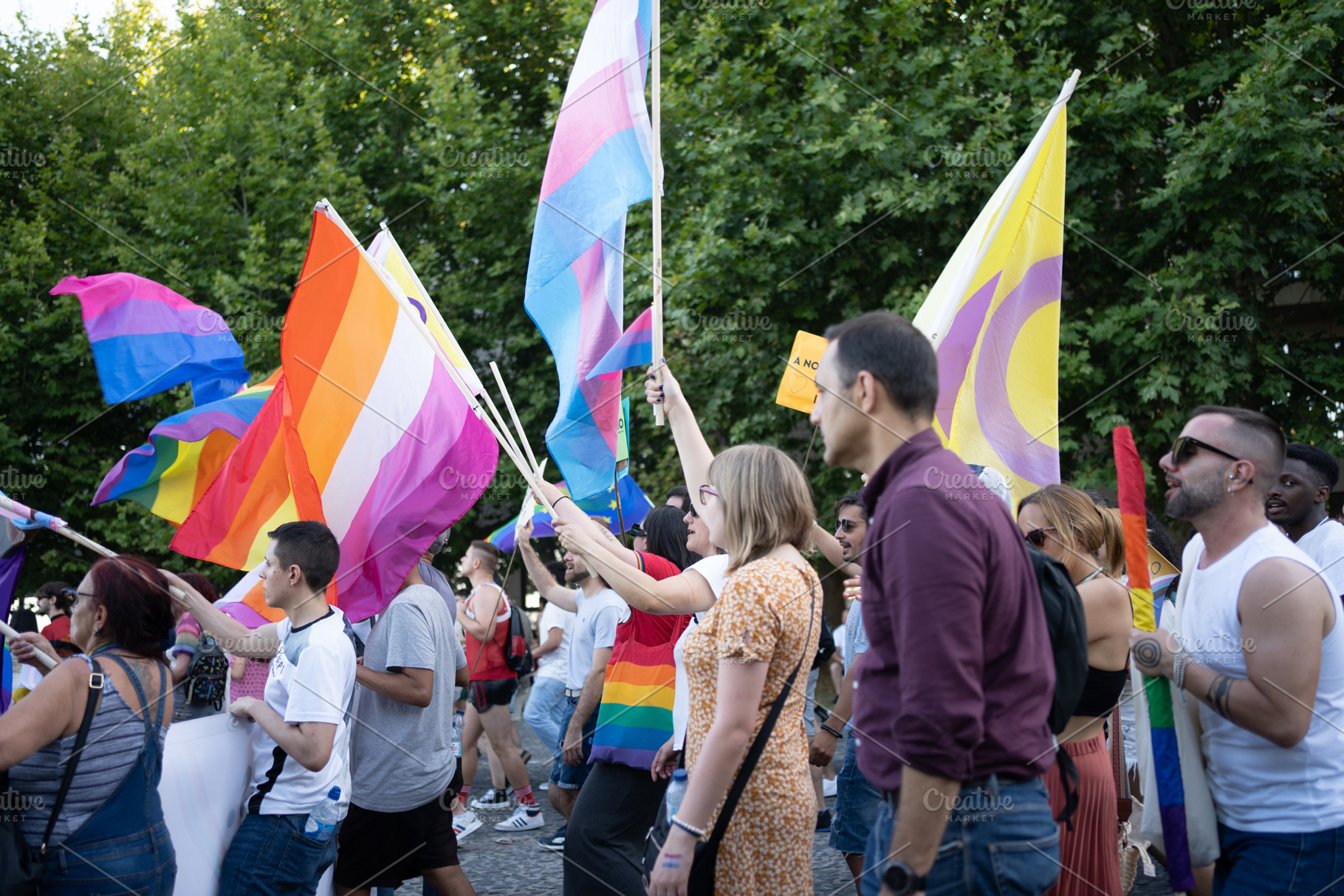 Group of homosexual people with rainbow flags at gay pride parade, a Photo by andreonegin market