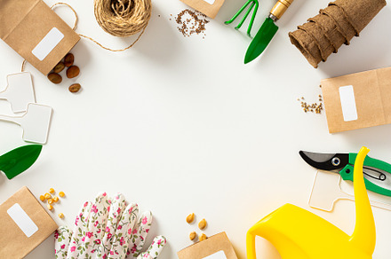 Flat lay gardening tools, peat pots, gloves, seeds packets, pruner, watering ca, a Holiday Photo by photoguns