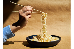 Woman hand holding chopsticks with, a Food & Drink Photo by Gladkov photography