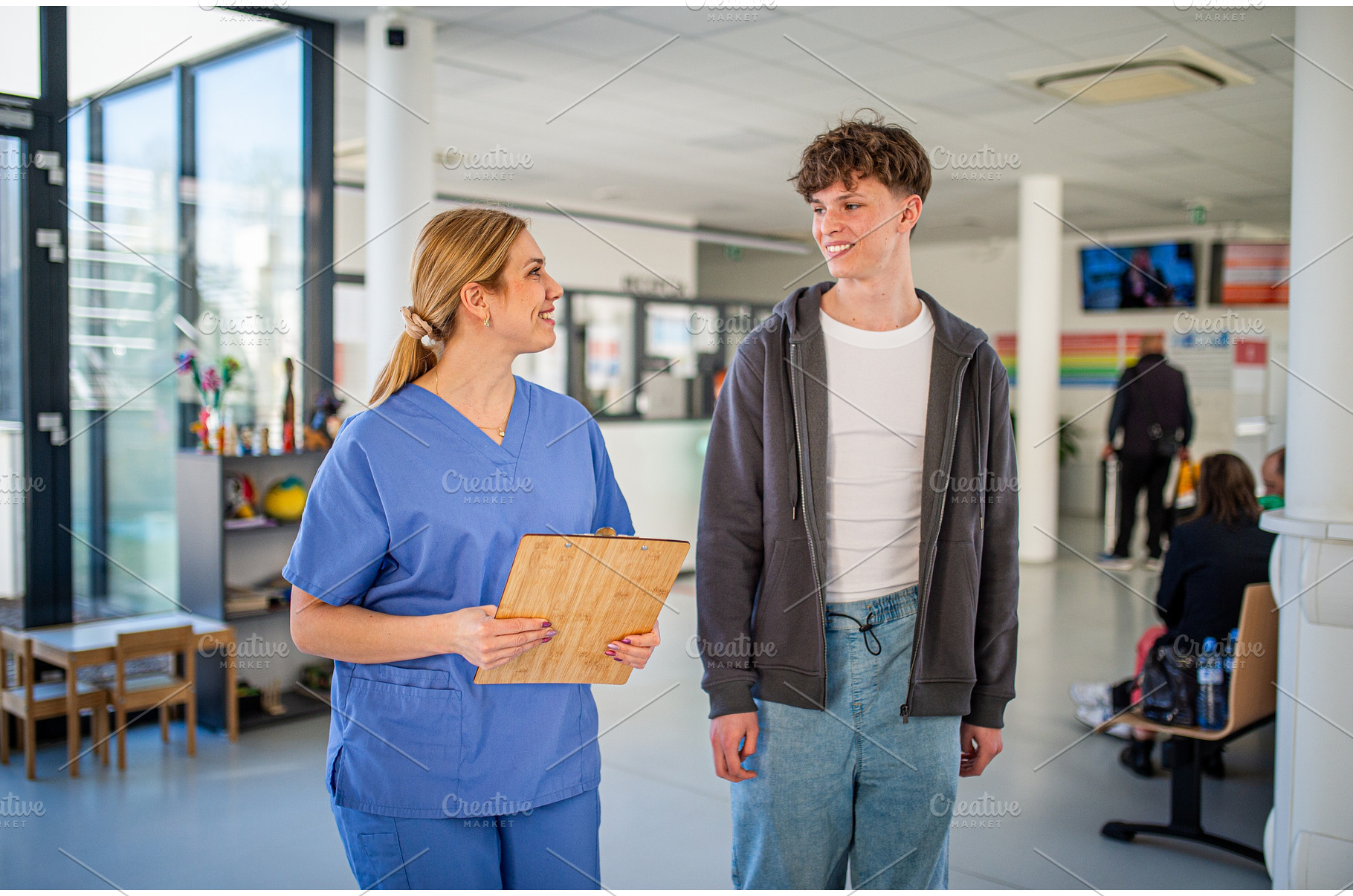 Doctor walking with teenage patient, a Person Photo by HalfPoint