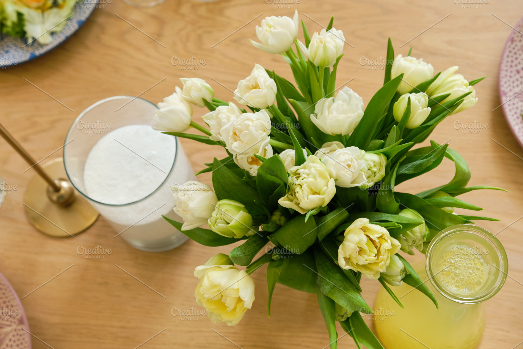 Top view of a beautiful bouquet of white tulips in a glass vase on a wooden tab, a Food & Drink Photo by Rohan Photography