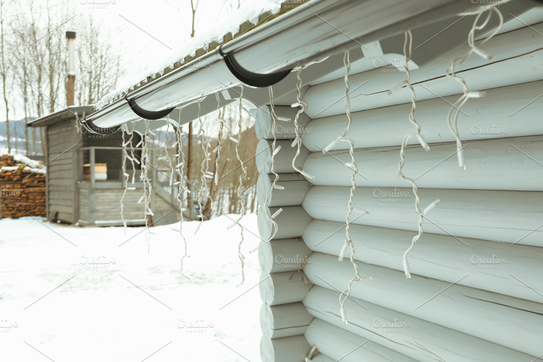 Cozy wooden house with garland in winter season, a Holiday Photo by AtlasStudio PRO