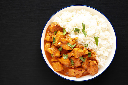 Homemade Easy Indian Butter Chicken with Rice on a Plate on a bl, a Food & Drink Photo by LiudmylaChuhunova