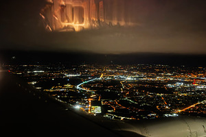 Stunning night aerial view of Krakow city lights from an airplane window over P, a Photo by AS photostudio