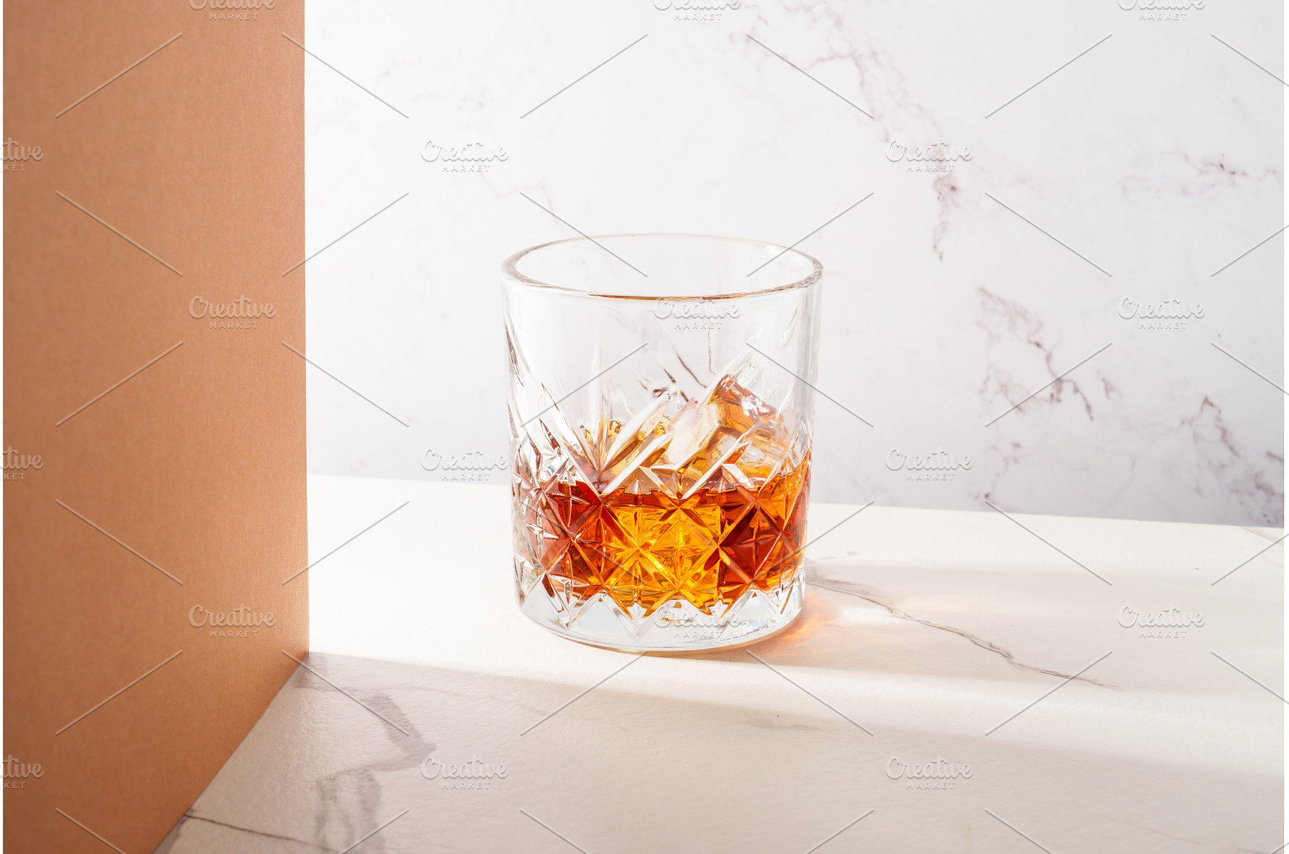 Whiskey with ice cube in the glass, a Food & Drink Photo by Nadia-nb
