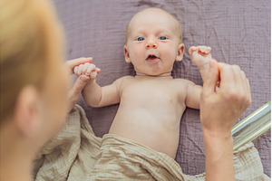 A mother gently massages her 1-month, a Person Photo by Elizaveta Galitskaya