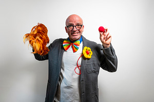 Performer with red wig and clown nose ready for show, a Person Photo by karrastock