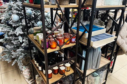 Christmas decorations and home goods displayed on organized shelving in a store, a Photo by AS photostudio