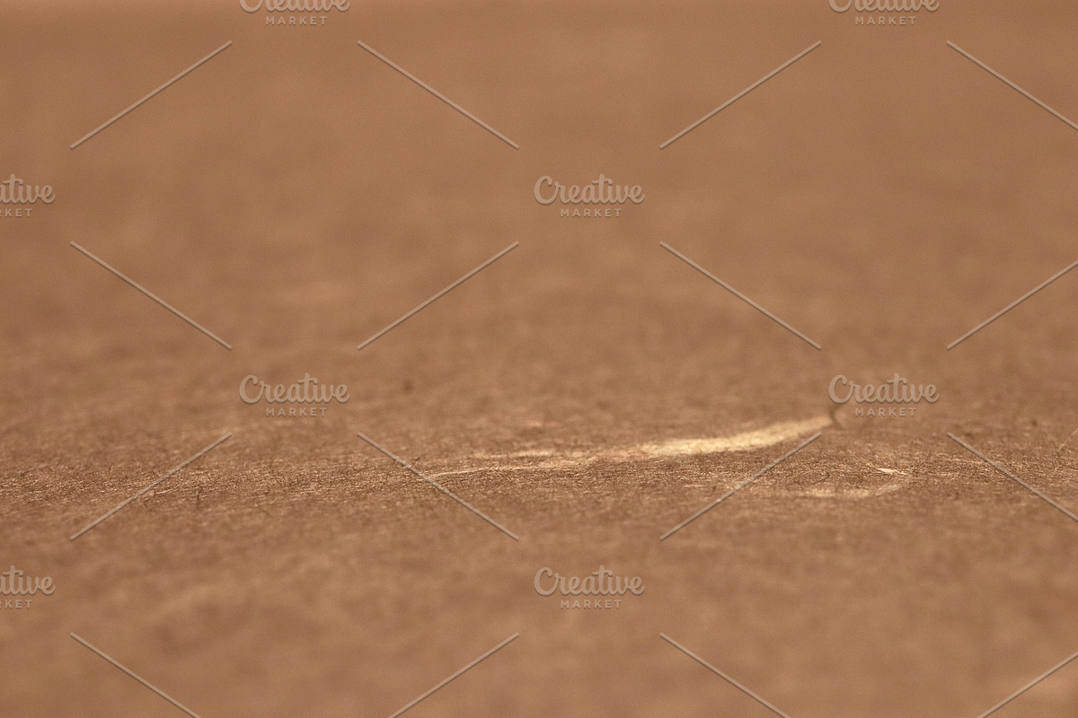 Close-up of a scratch on a brown paper texture surface., a Texture Graphic by Textures & Backgrounds