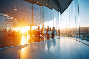 Modern open space office features glass walls and a sunset view over the city, a Photo by AlyaAnd