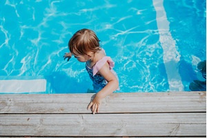 Little girl playing in shallow water, a Person Photo by HalfPoint
