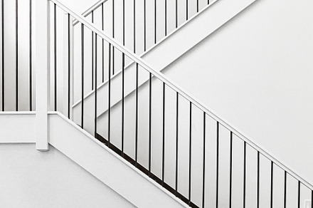 Modern white wooden staircase in new house interior with big windows