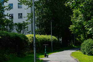 Pathway with trees and parked electric scooter in Reykjavik, Iceland, a Photo by AS photostudio