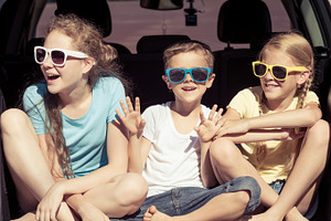 Happy kids sitting in the car containing car, child, and family