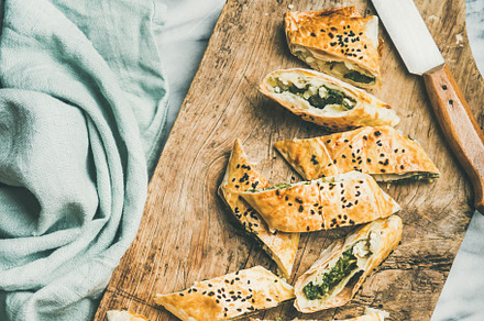 Freshly baked Turkish borek roll cut in slices, square crop, a Food & Drink Photo by Foxys