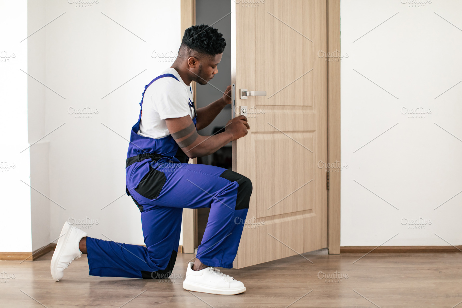 African American Male Worker Installing New Door In Apartment Indoor, a Photo by Prostock-Studio