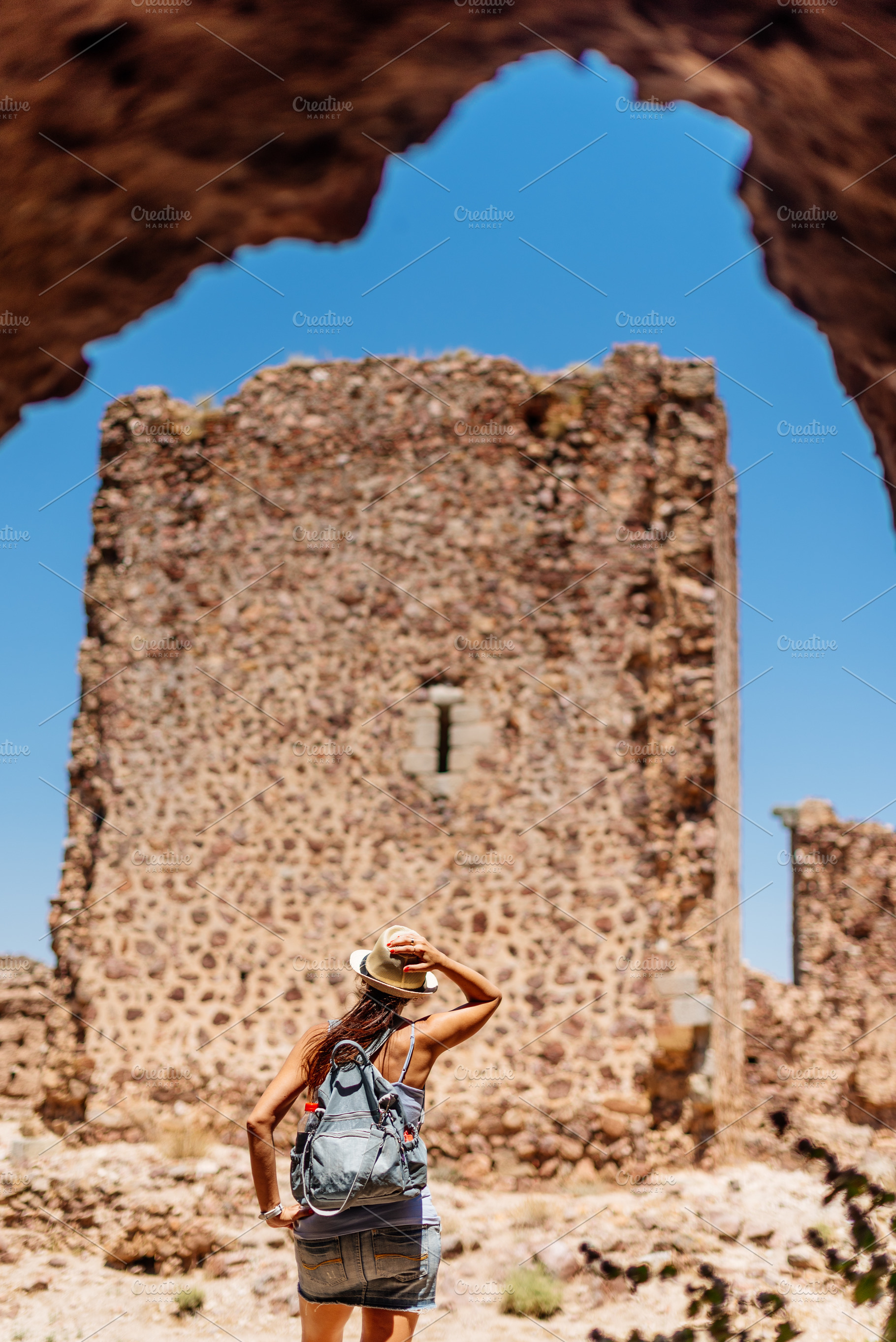 Tourist looking at the wall of a medieval castle., a Holiday Photo by Iván Moreno STOCK PHOTO