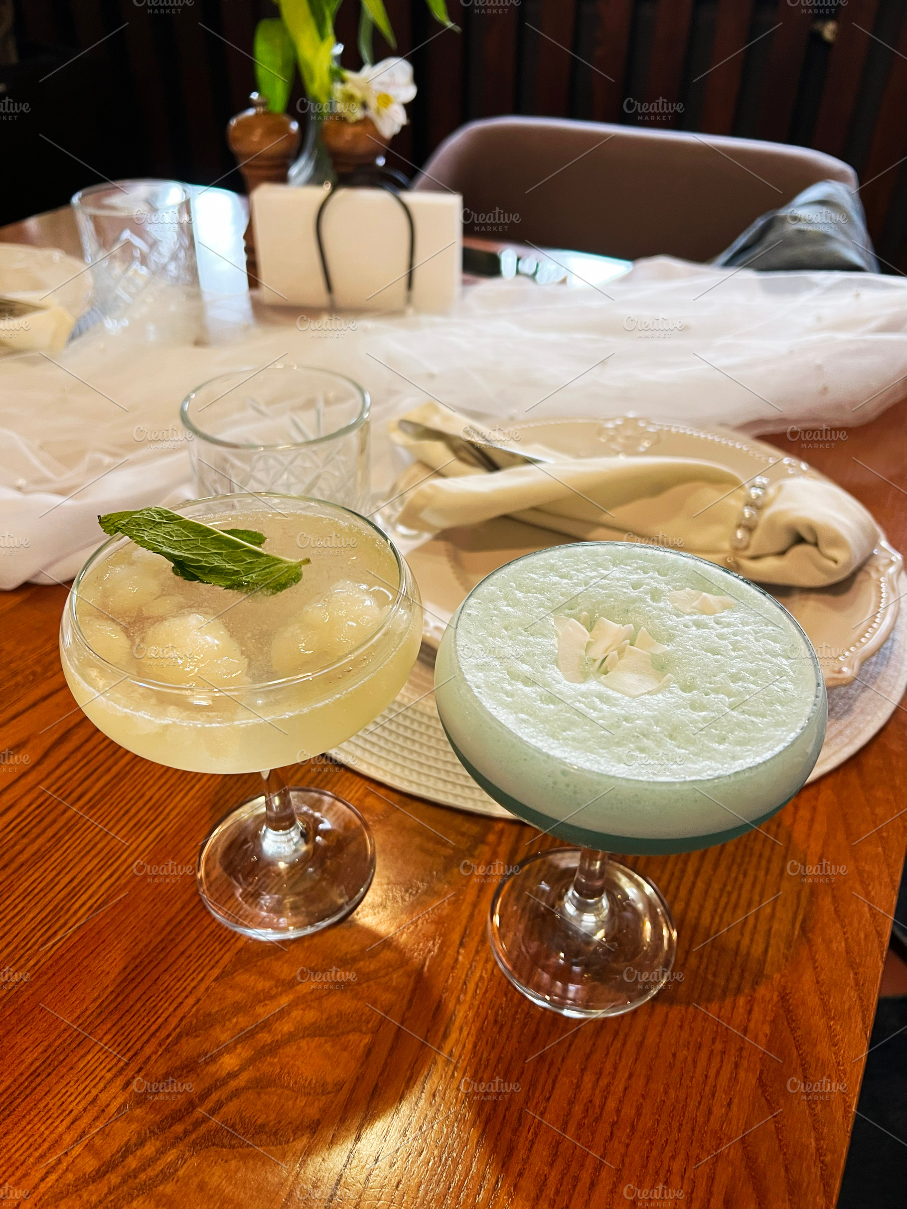 Elegant table setting with crafted cocktails and intricate dinnerware, a Photo by AS photostudio