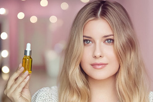 Woman holding a dropper bottle with natural skincare oil, promot, a Person Photo by Studio ANNA
