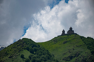 Ancient Gergeti Trinity Church on green hill under cloudy sky in, a Photo by Pictures for you!!!!!!!!!