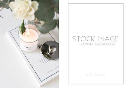 Candle and book in flowers, a Business Photo by Una Matison