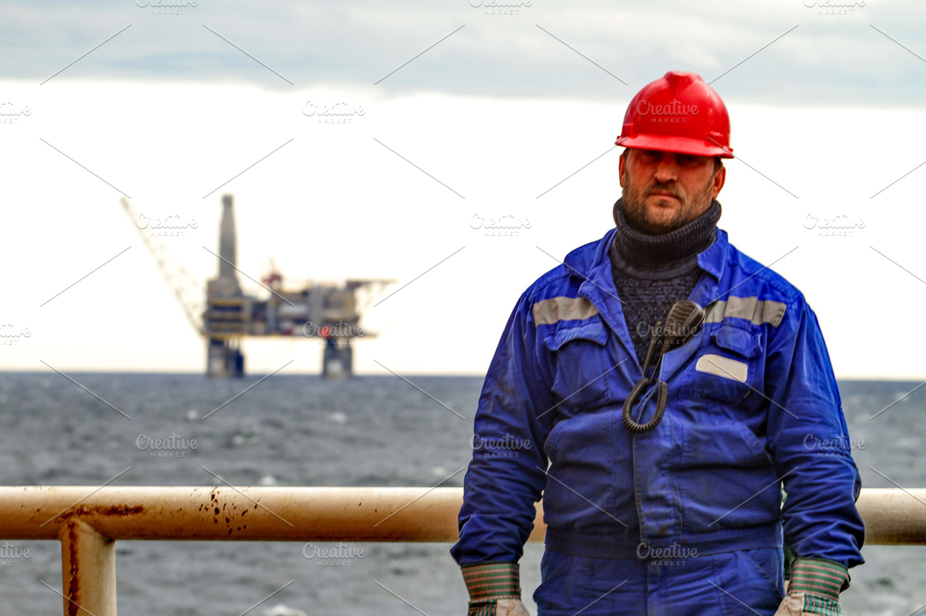 Oilman shift workers on the deck of the ship on the background offshore oil, a Person Photo by ELEONIMAGES