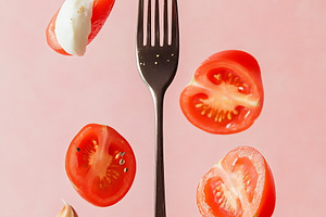 Floating tomatoes and cheese on fork, a Photo by Beautiful things