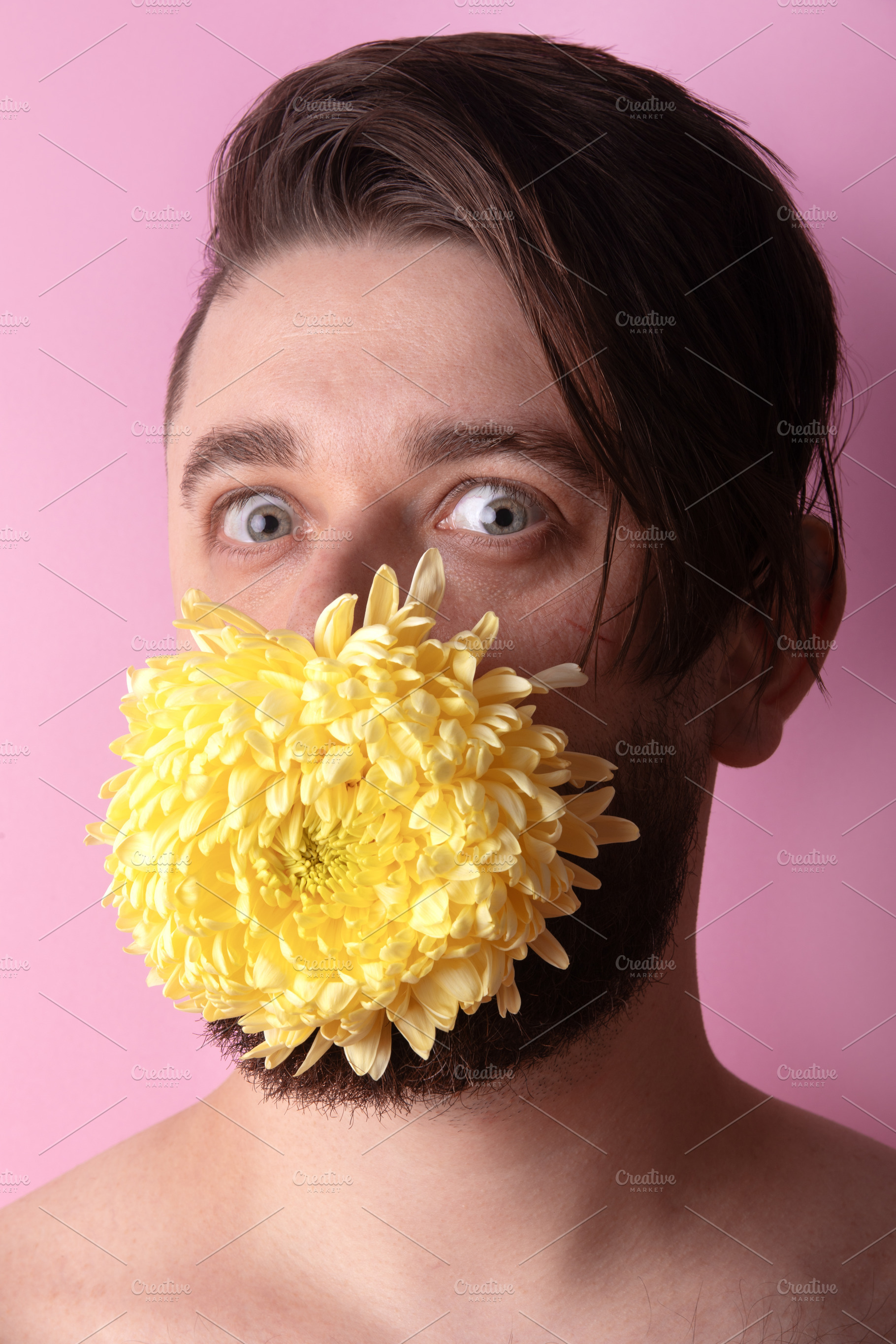 Young man with large yellow chrysanthemum covering mouth, standi, a Person Photo by Ales Munt