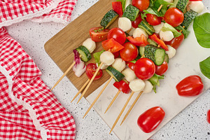 Light summer appetizer of vegetables and cheese on skewers on a, a Food & Drink Photo by ndanko