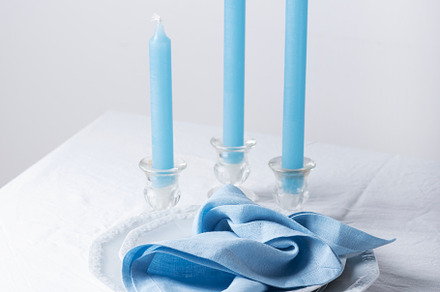 Blu linen napkins and blu candles on the white table